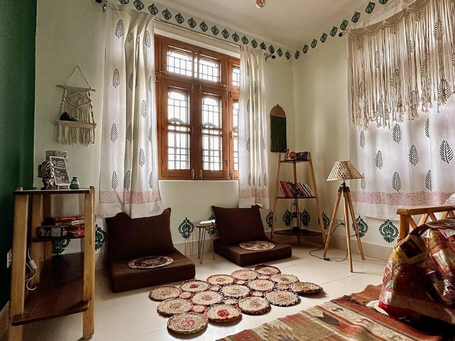 een woonkamer met een bed en een groot raam bij Aikyam Niwas - 1BHK Apartment in Pālampur