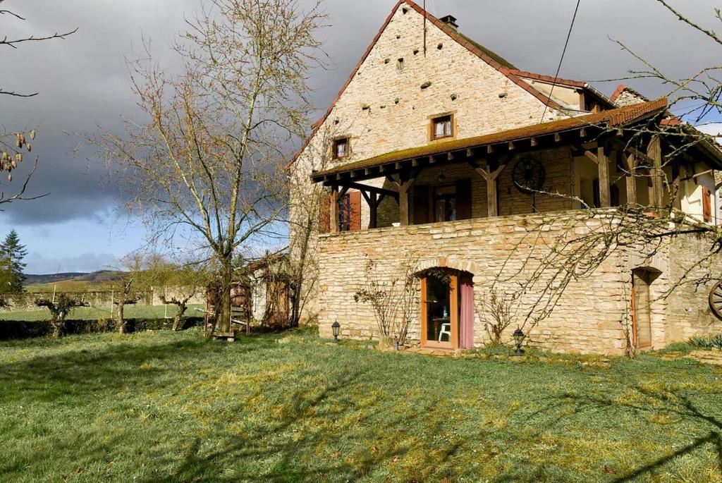 una vieja casa de piedra en un campo de hierba en Charming Country House In The Heart Of Burgundy, en Cormatin