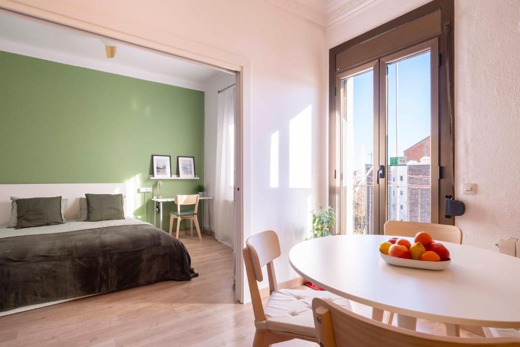 ein Schlafzimmer mit einem Bett und einem Tisch mit einer Schale Obst in der Unterkunft Sunny Apt Barcelona 22@ in Barcelona