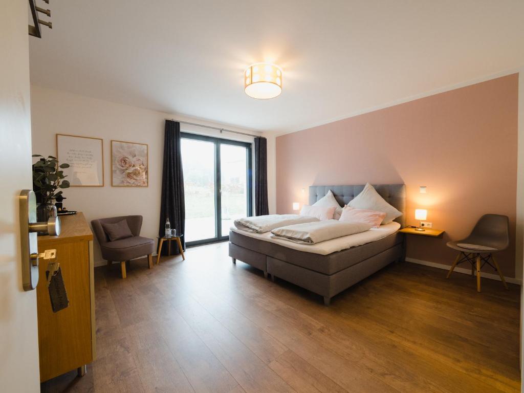 een slaapkamer met een bed en een groot raam bij Gästehaus Frieda in Schweigen-Rechtenbach