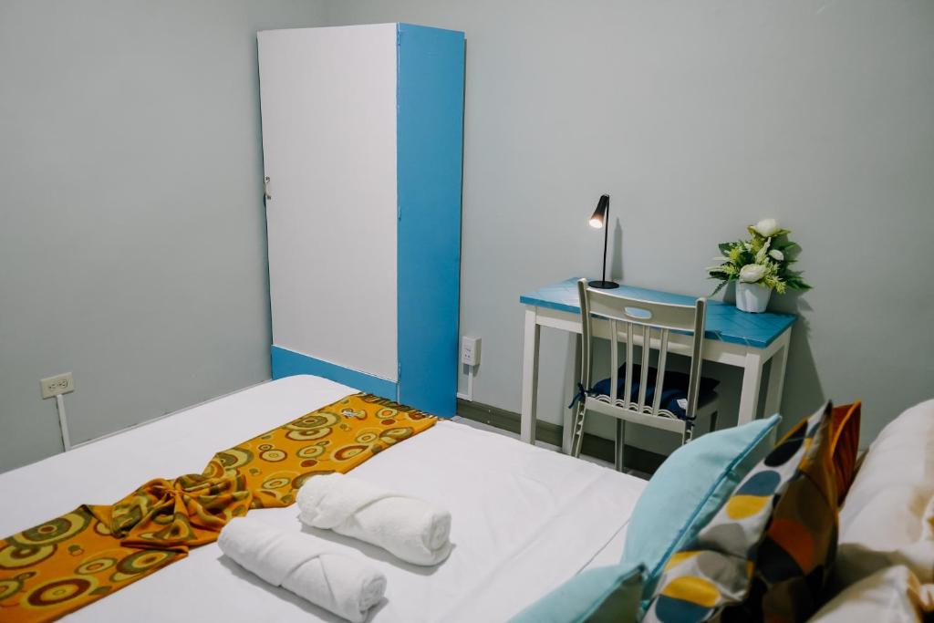 Habitación pequeña con cama y escritorio con mesa. en Near Airport Transient Inn 2-Bedroom Space -Richkizz 1, en Puerto Princesa City