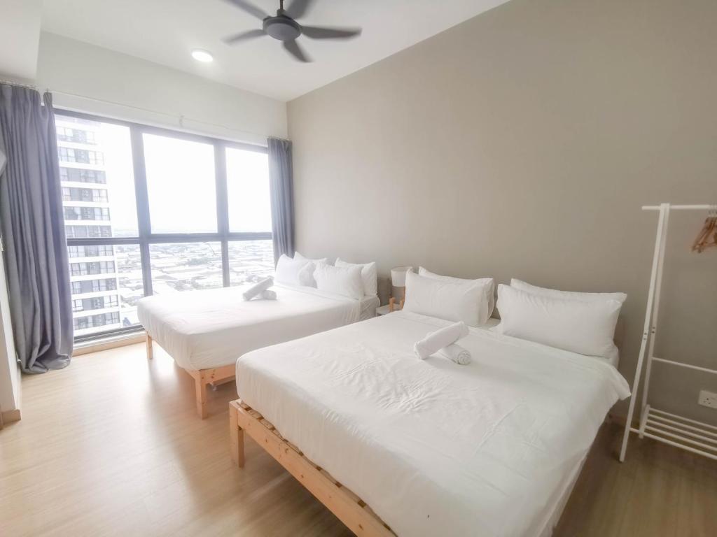 two beds in a room with a large window at D' Sara Sentral Suites by Manhattan Group in Sungai Buluh