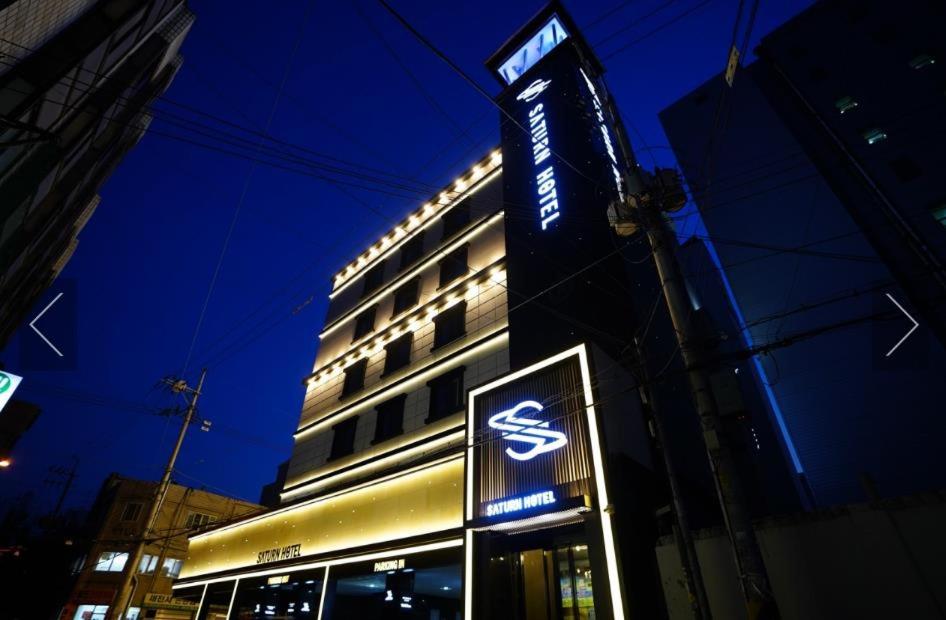 un bâtiment avec un panneau devant lui la nuit dans l'établissement Dongdaemun Saturn Hotel, à Séoul