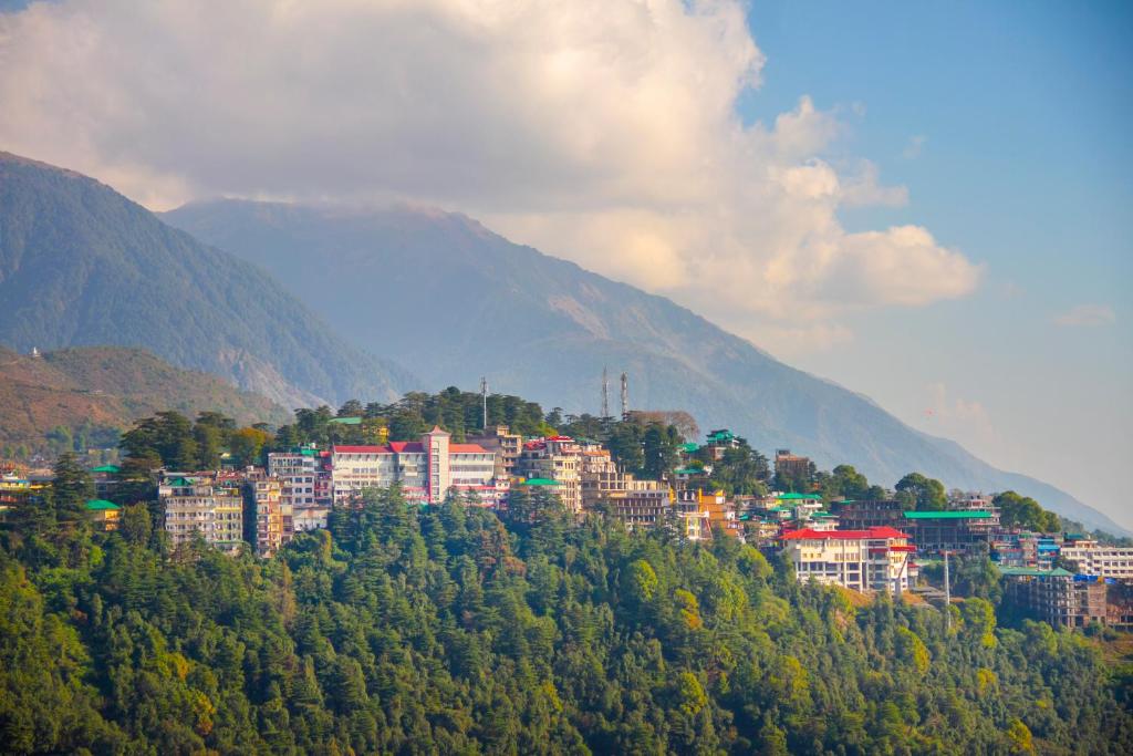 a city on top of a hill with trees at Amritara Surya, Mcleodganj, Dharamshala in Dharamshala