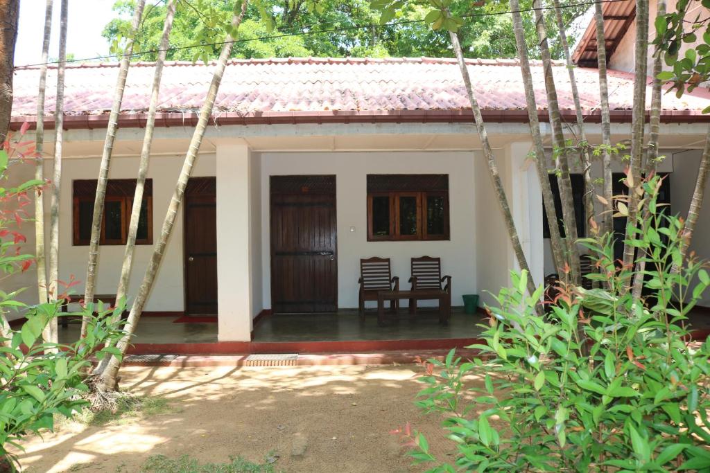 una casa con due sedie davanti di Polonnaruwa Holiday Inn a Polonnaruwa