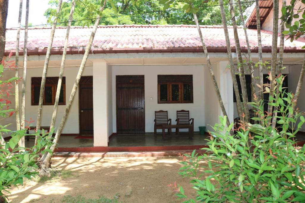 波隆納魯沃的住宿－Polonnaruwa Holiday Inn，前面有两把椅子的房子