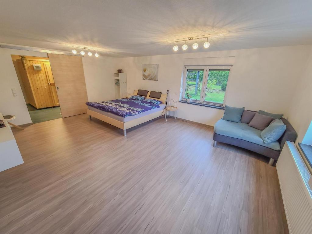 um quarto com uma cama e um sofá em Ferienwohnung "Urlaub bei Lina" em Hergatz