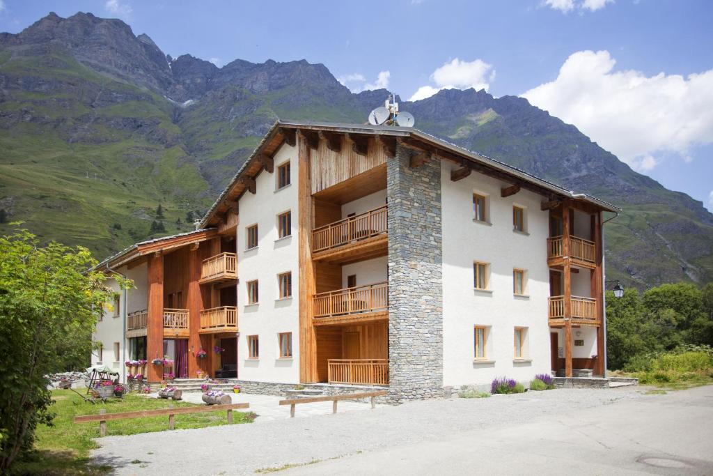 an apartment building with mountains in the background at Chalet l&#39;aubépine résidence B&amp;B in Bessans