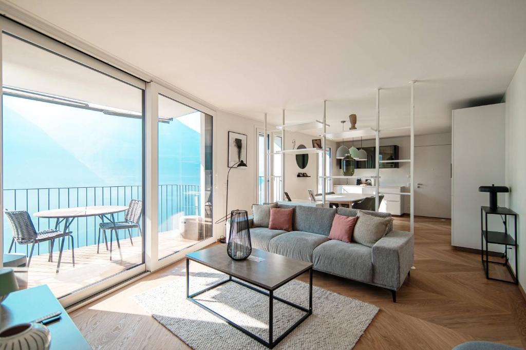 uma sala de estar com um sofá e uma mesa em Unique Gandria 3 by Quokka 360 - luxury two-bedroom apartment with a breathtaking view em Lugano