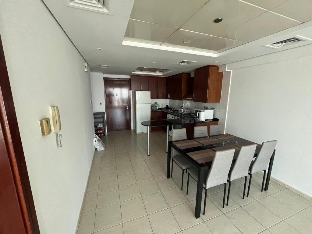 uma cozinha e sala de jantar com mesa e cadeiras em Cozy 1-br apartment in JLT near DMCC Metro em Dubai