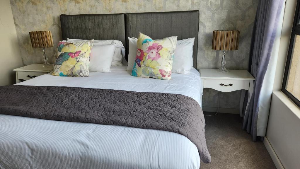 a bedroom with a bed with pillows and two tables at Zimbali Suite 508 in Ballito