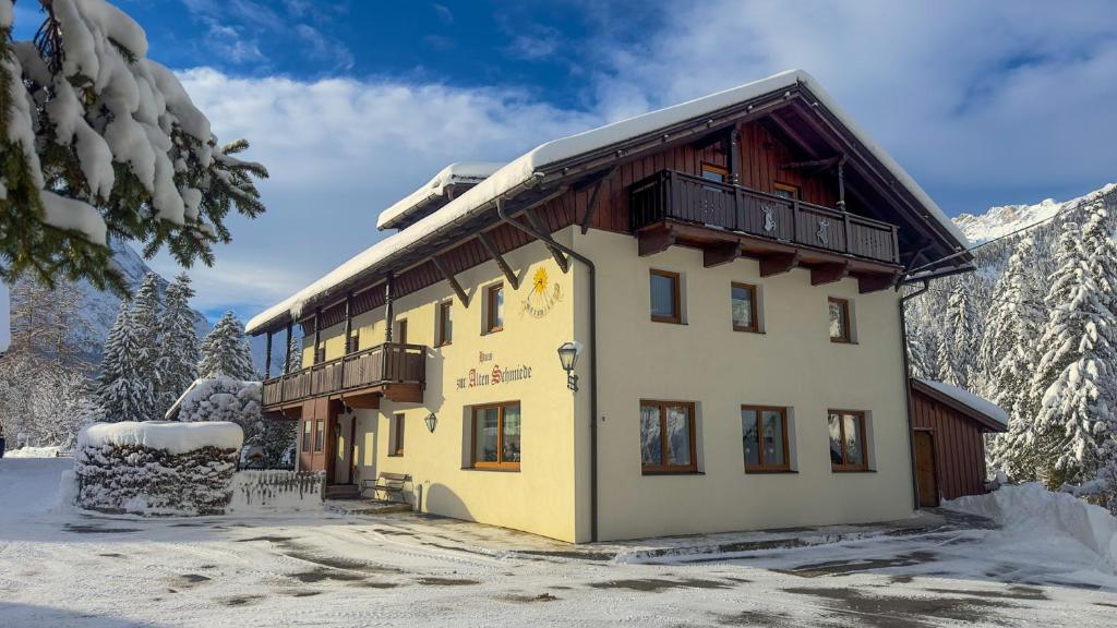un bâtiment dans la neige avec des montagnes enneigées dans l'établissement Alte Schmiede, à Leutasch