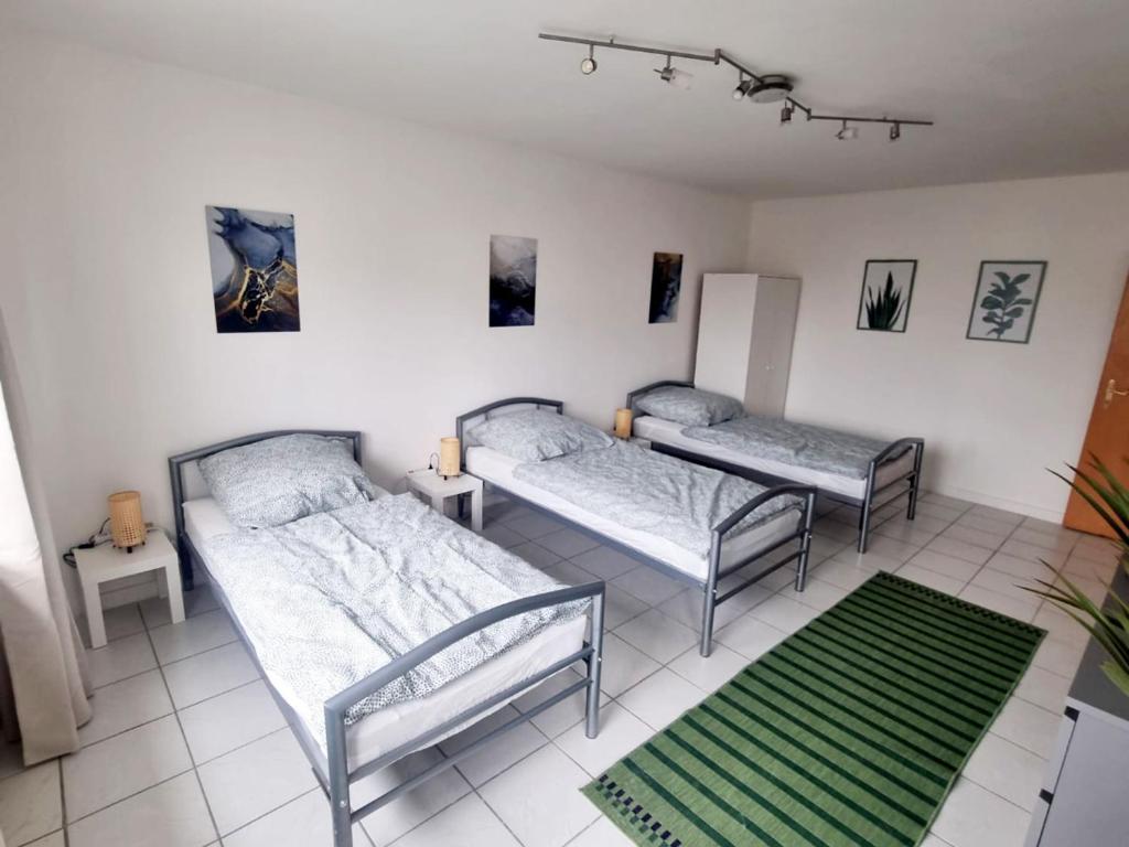 Habitación con 2 camas y alfombra verde. en Apartment with Balcony in Mönchengladbach, en Mönchengladbach