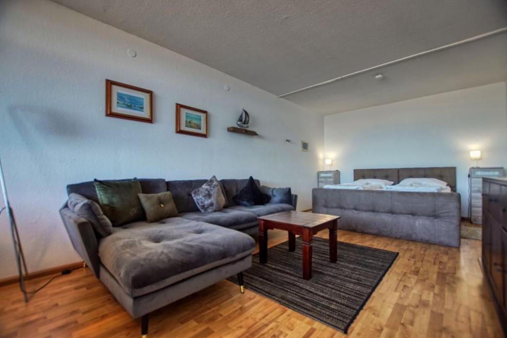 ein Wohnzimmer mit einem Sofa und einem Bett in der Unterkunft Ferienpark - Haus A, App 0A0703 in Heiligenhafen