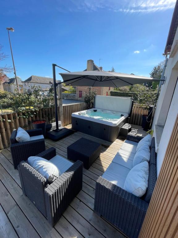 una terraza con sillas, una sombrilla y una piscina en Résidence Cosy, en La Mézière