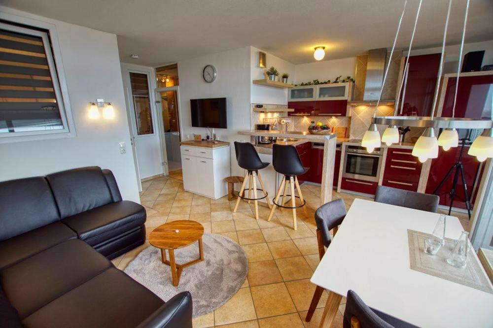 cocina y sala de estar con sofá y mesa en Ferienpark - Haus B, App 0B0606, en Heiligenhafen