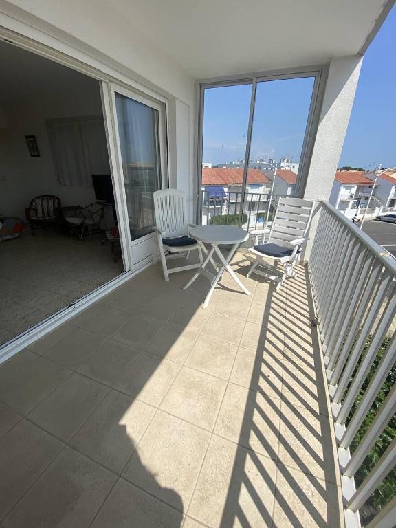 - un balcon avec deux chaises et une table dans l'établissement BOUCANET Appartement P3 vue sur mer - 2 CHAMBRES POUR 6 PERSONNES - LOGGIA, au Grau-du-Roi