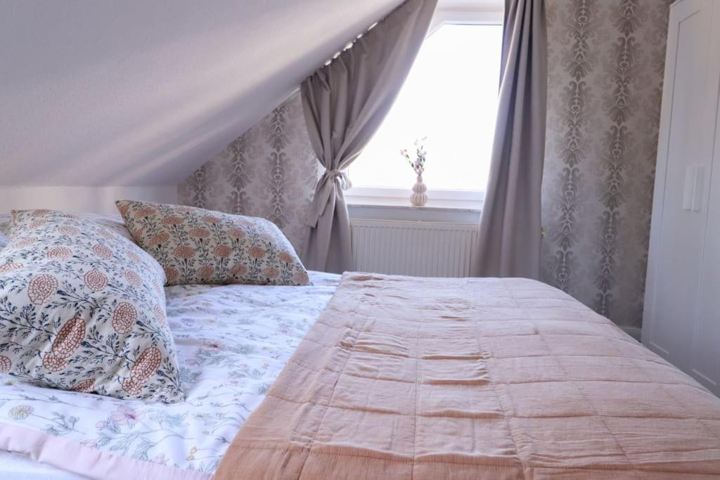 - une chambre avec un lit doté d'oreillers et d'une fenêtre dans l'établissement Naturzauber im Harz, à Bad Lauterberg