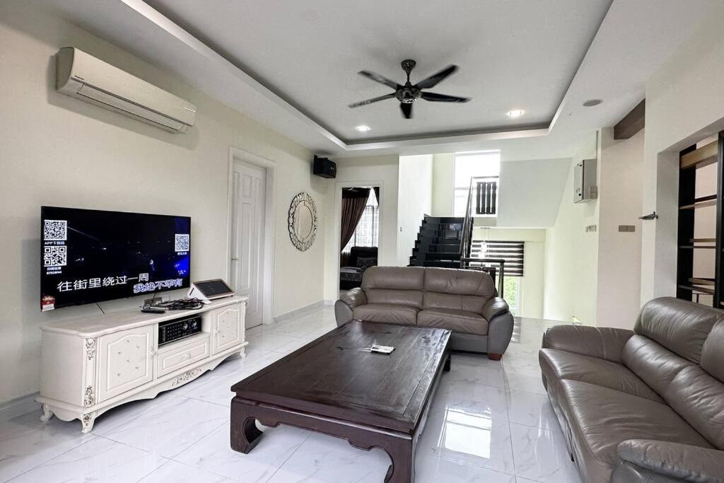 a living room with a couch and a flat screen tv at 21pax KL Event Bungalow in Ampang