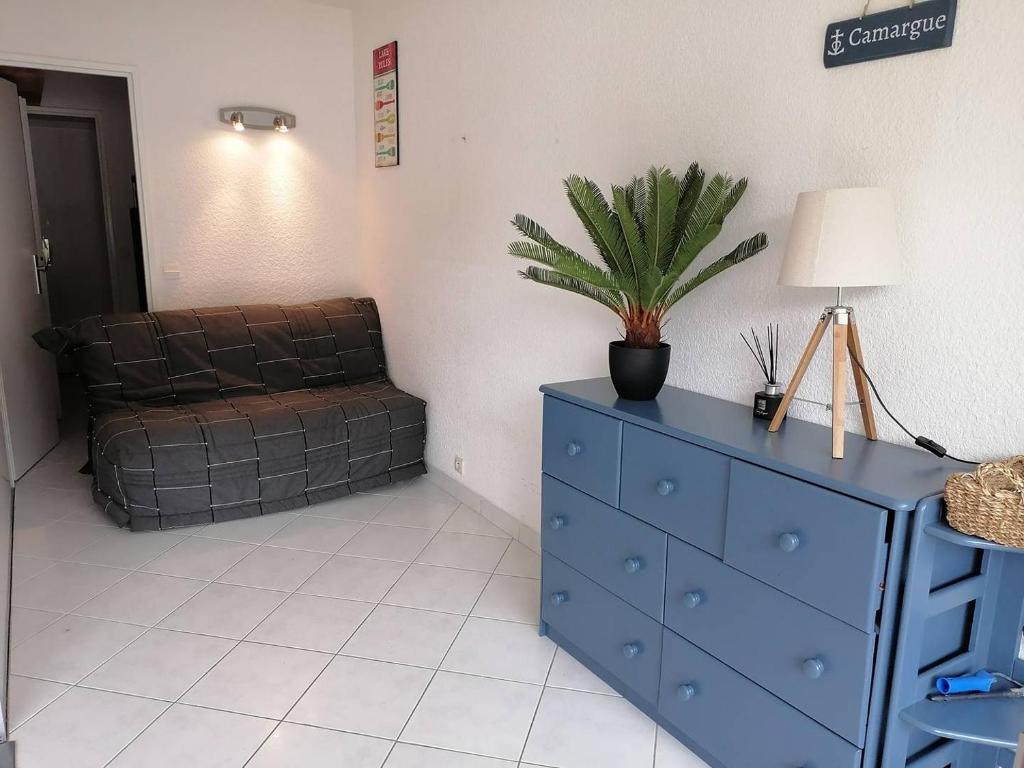 - un salon avec une commode bleue et un canapé dans l'établissement APPARTEMENT 1 CHAMBRE 4 PERSONNES EN REZ DE CHAUSSEE DANS RESIDENCE AVEC PISCINE, au Grau-du-Roi