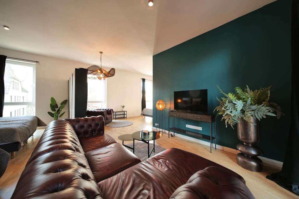 a living room with a leather couch and a flat screen tv at Urban retreat loft in the center in Koblenz