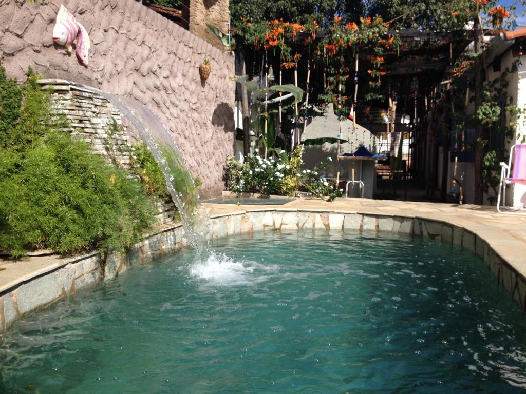 uma fonte no meio de uma piscina de água em Casamatta Hostel em Pirenópolis