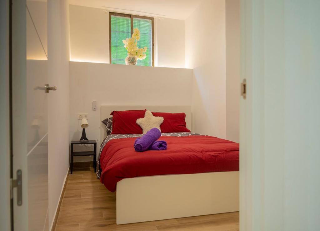 um quarto com uma cama vermelha e branca e uma janela em Bilbao centro Zumaia2 em Bilbao