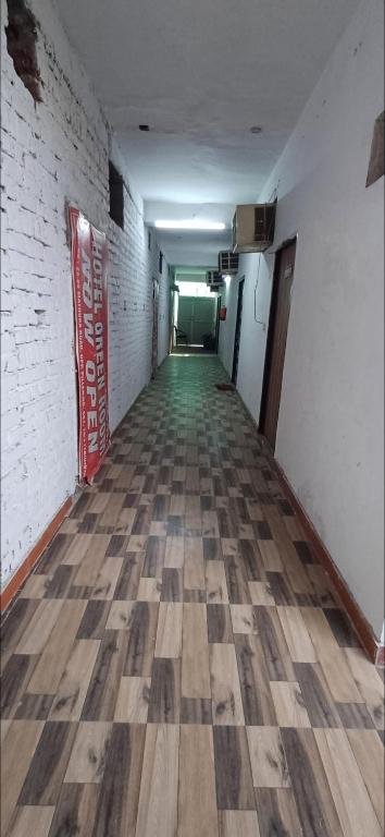 um corredor vazio com uma parede de tijolos e pisos de madeira em Hotel green em Faridabad