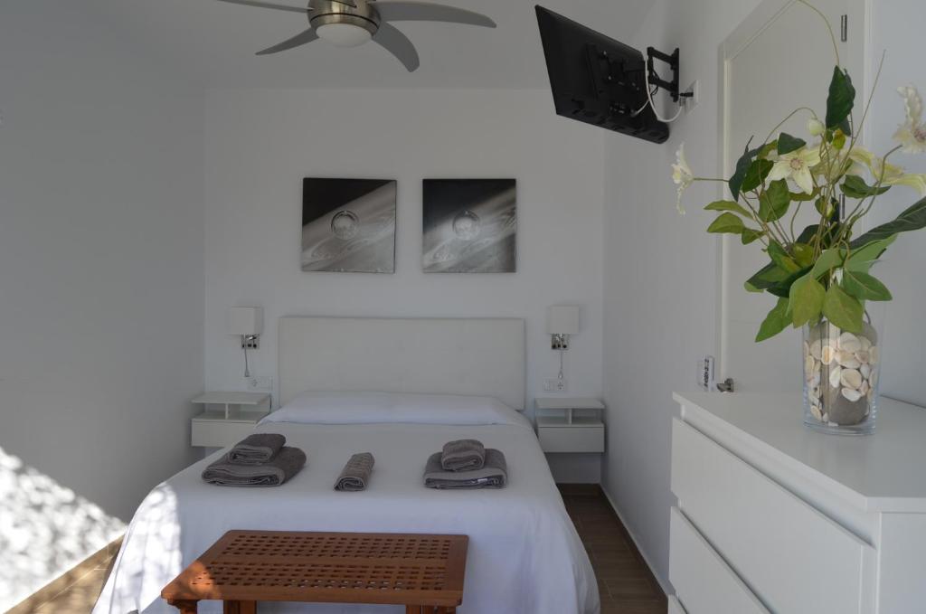 ein Schlafzimmer mit einem Bett und einem TV an der Wand in der Unterkunft EL ENCANTO II PISCINA PRIVADA WIFI BARBACOA PARKING AIRE Ac in Chiclana de la Frontera