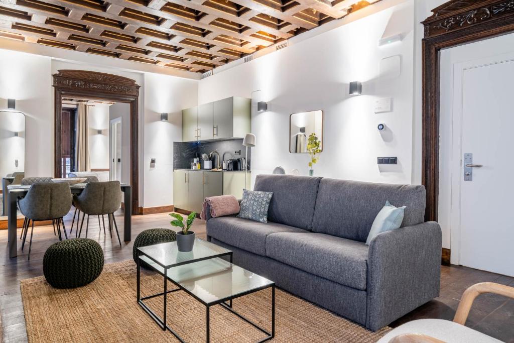 ein Wohnzimmer mit einem Sofa und einem Tisch in der Unterkunft limehome Vitoria Palacio de los Álava-Velasco in Vitoria-Gasteiz