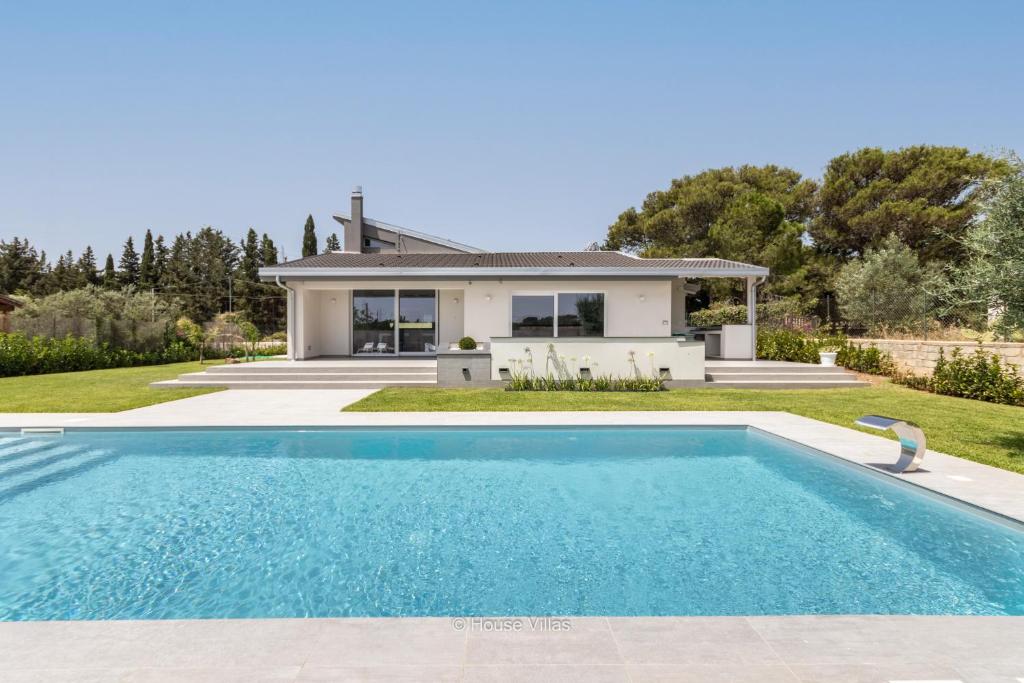 une villa avec une piscine en face d'une maison dans l'établissement FlaBen Luxury Villa, à Avola