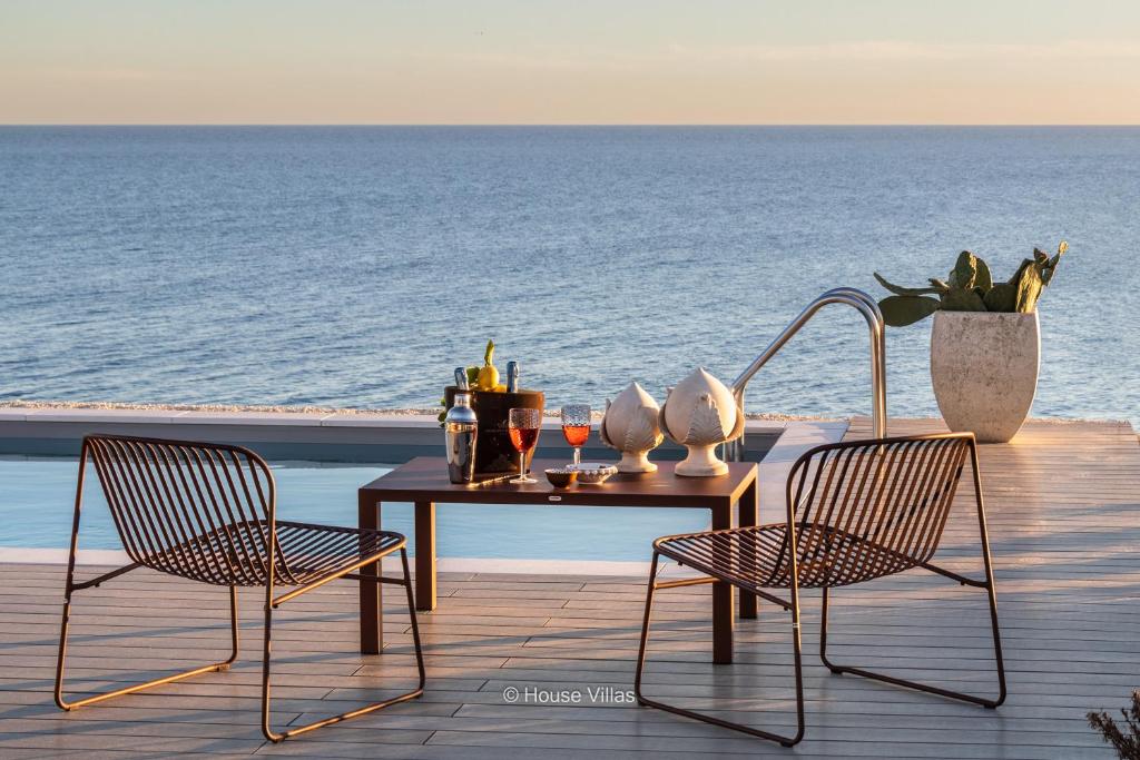 una mesa y dos sillas en una terraza con vistas al océano en Villa DeMar, en Plemmirio