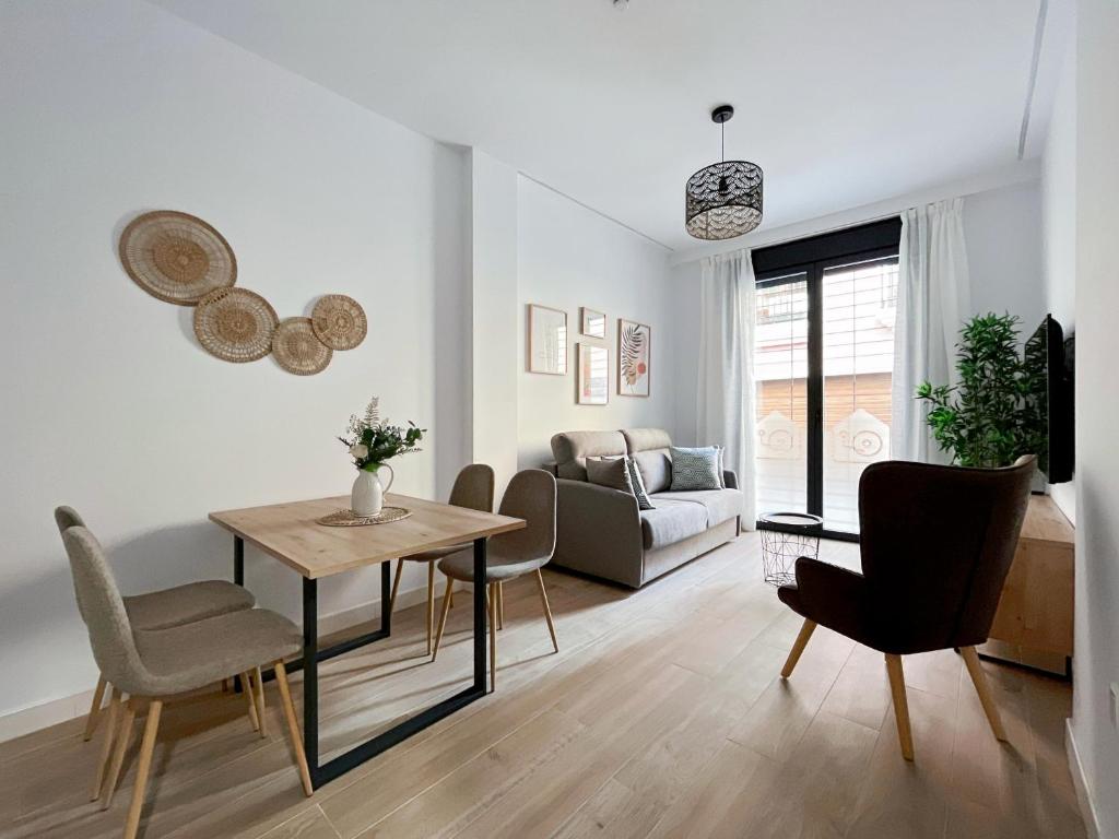 een woonkamer met een tafel en stoelen en een bank bij Picú Home - Nueva apertura in Málaga