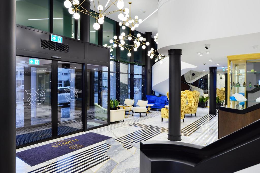 a lobby of a store with yellow chairs and tables at Hotel Ferreus Modern Art Deco in Krakow