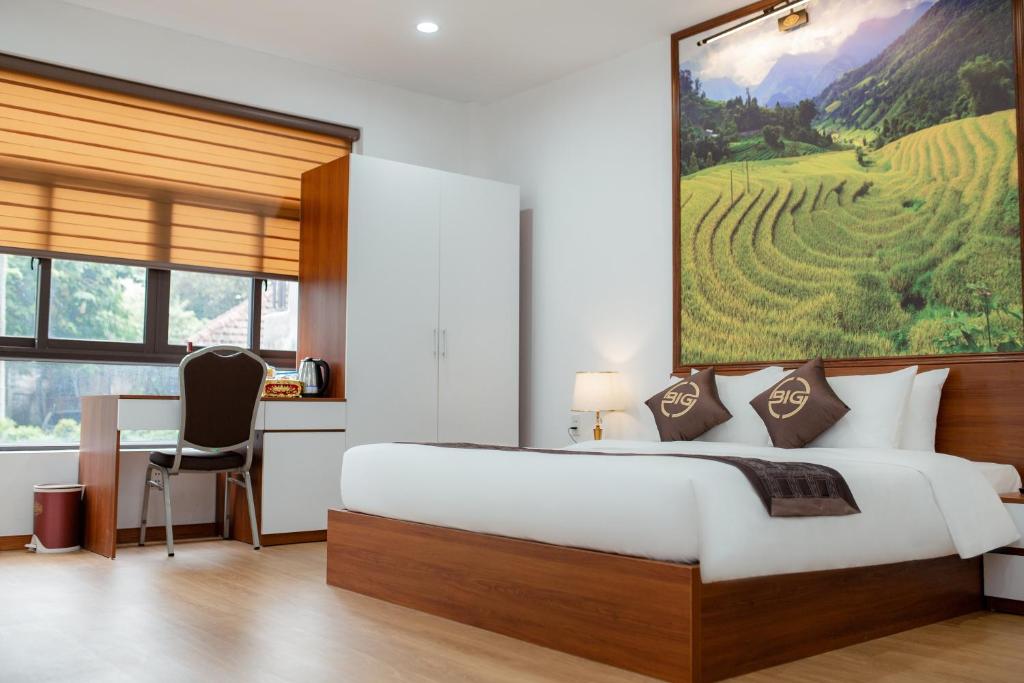 a bedroom with a large bed and a desk at Big Hotel Lào Cai in Lao Cai