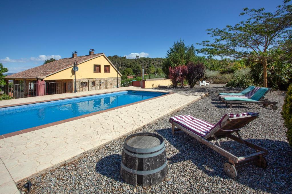 a swimming pool with a chair and a barrel next to it at Aaccent Montblanc - Prenafeta in Montblanc