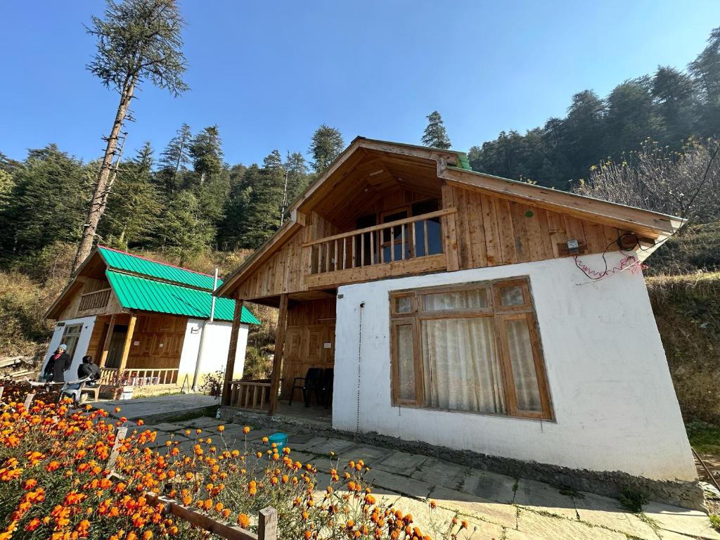 ein kleines Holzhaus mit grünem Dach in der Unterkunft Himalayan Mountain View Cottage Deohari in Sainj