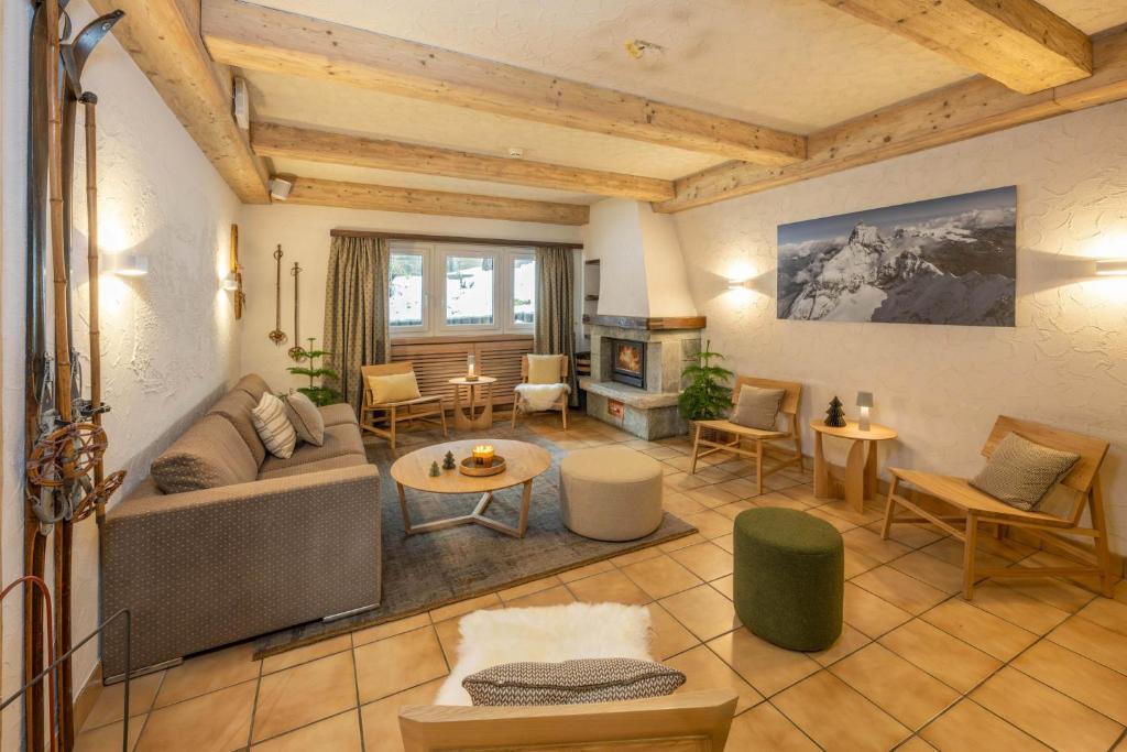 a living room with a couch and a fireplace at Hotel Sarazena in Zermatt