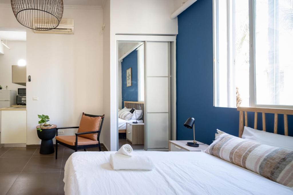 a bedroom with a white bed and a blue wall at The Printhouse - Downtown Boutique Apartments by Sea N' Rent in Haifa