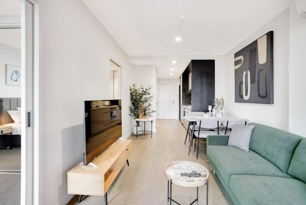 een woonkamer met een groene bank en een tafel bij "Hidden Gem" Cosy 2B apt in central Melbourne#UT2602 in Melbourne