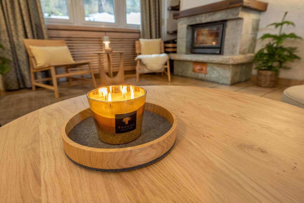 una vela sobre una mesa de madera en la sala de estar en Hotel Sarazena, en Zermatt