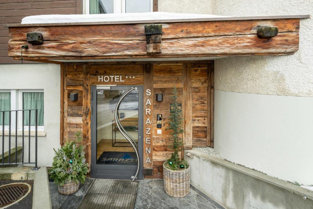 una entrada del hotel con una puerta y plantas delante en Hotel Sarazena, en Zermatt