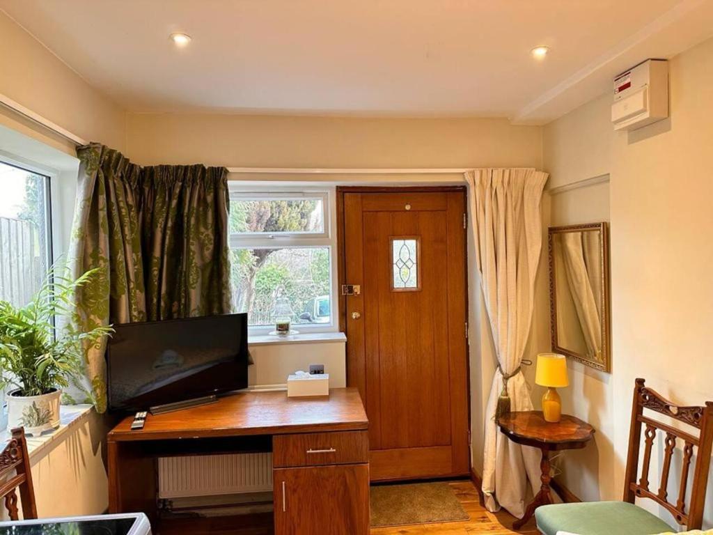 a room with a desk with a television and a window at Fab Studio Room in Botley Oxford in Oxford