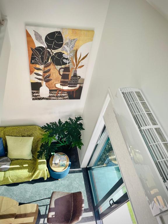 a living room with a couch and a window at Sunny Oasis- Modern Loft Hidden on Cashel in Christchurch