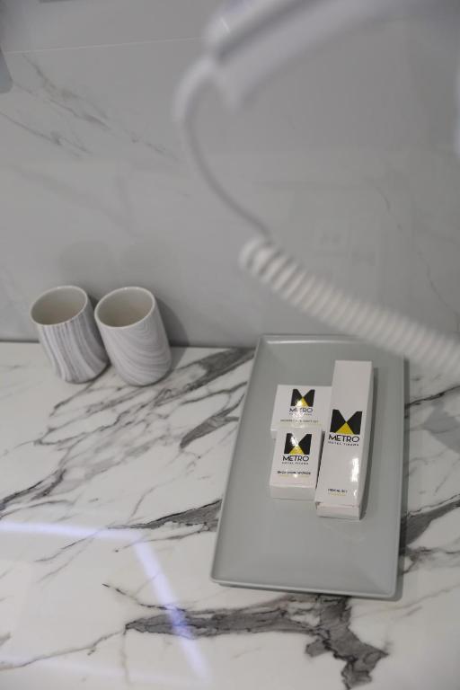 a laptop sitting on a marble counter with two vases at Metro Hotel Terminal in Tirana