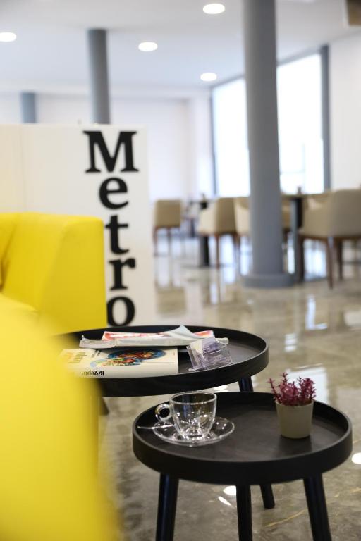 two black tables in a room with chairs at Metro Hotel Terminal in Tirana