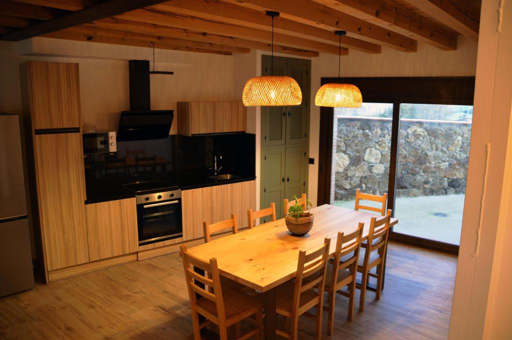 a kitchen and dining room with a wooden table and chairs at Casas Las Hazas in La Cuesta