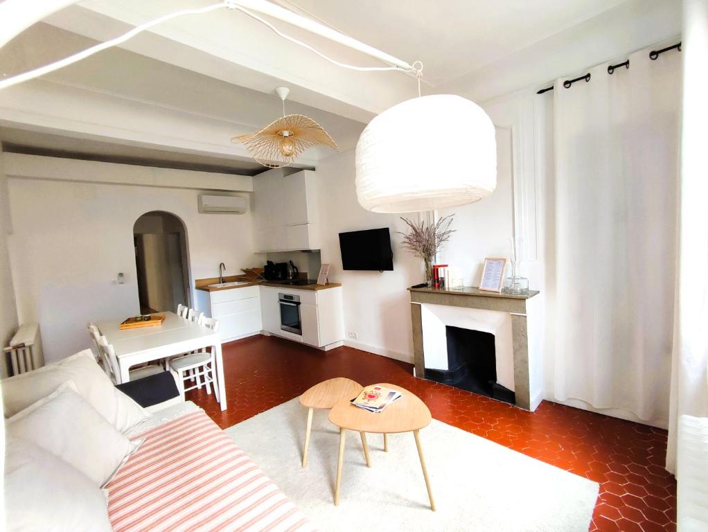 sala de estar con sofá blanco y chimenea en Appartement clilmatisé parking gratuit surveillé en Aviñón