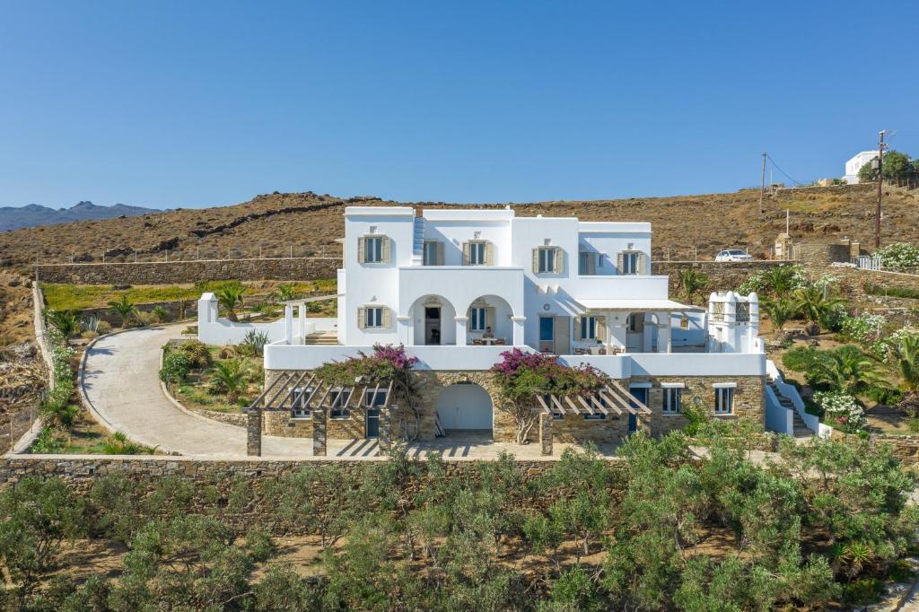 een groot wit huis midden op een heuvel bij La Chapelle Ouest & Guest suite in Agios Romanos