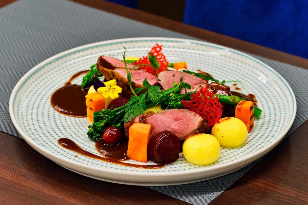 a plate of food with meat and vegetables on a table at Hotel Ferreus Modern Art Deco in Krakow